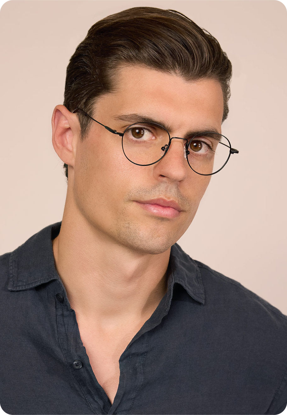 Man with diamond face shape dark hair wearing Oscar Wylee lightweight glasses.
