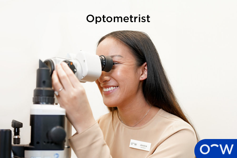 An optometrist performing an eye exam using a slit lamp.