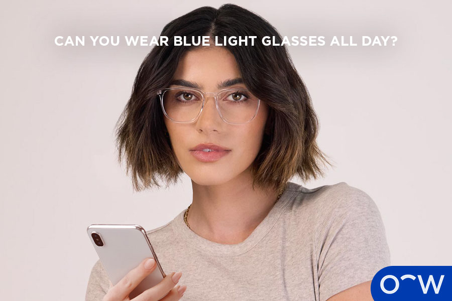 A person wearing blue light glasses whilst on their phone.
