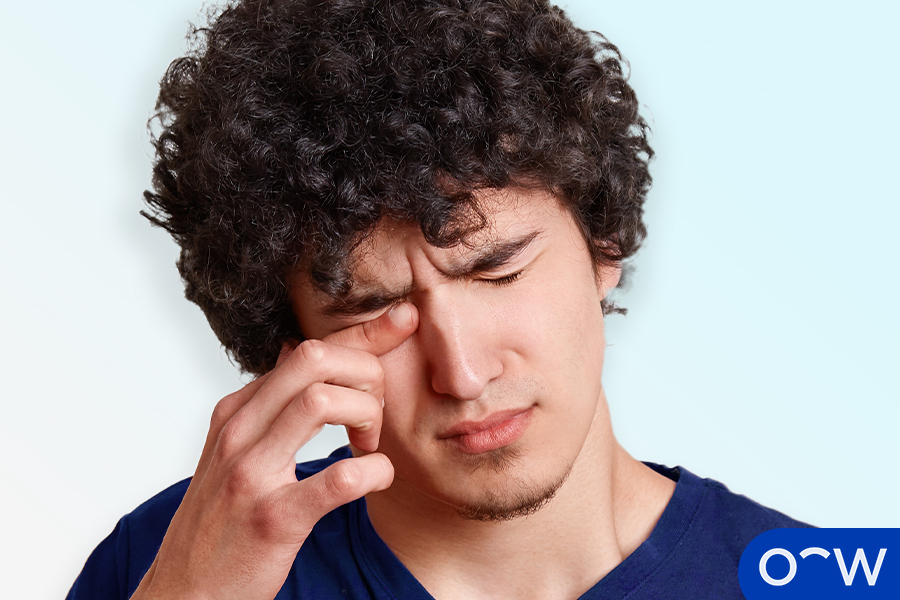A person rubbing their eye which is irritated by dirt or debris