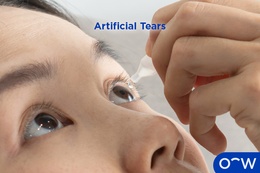 A woman putting artificial tears in her eyes.
