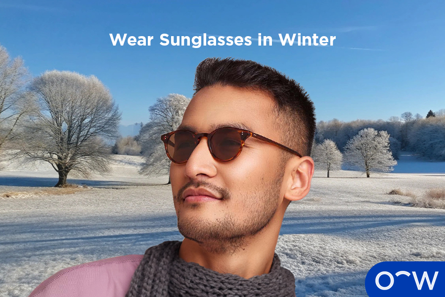 A man in a snow-covered landscape wearing sunglasses.