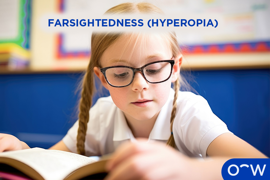 A child in school reading a book with glasses on to correct farsightedness.
