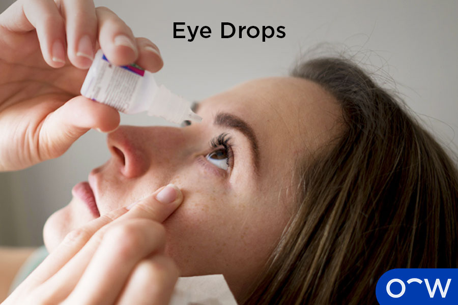 A woman applying eye drops to relieve eye pain caused by an eye condition.