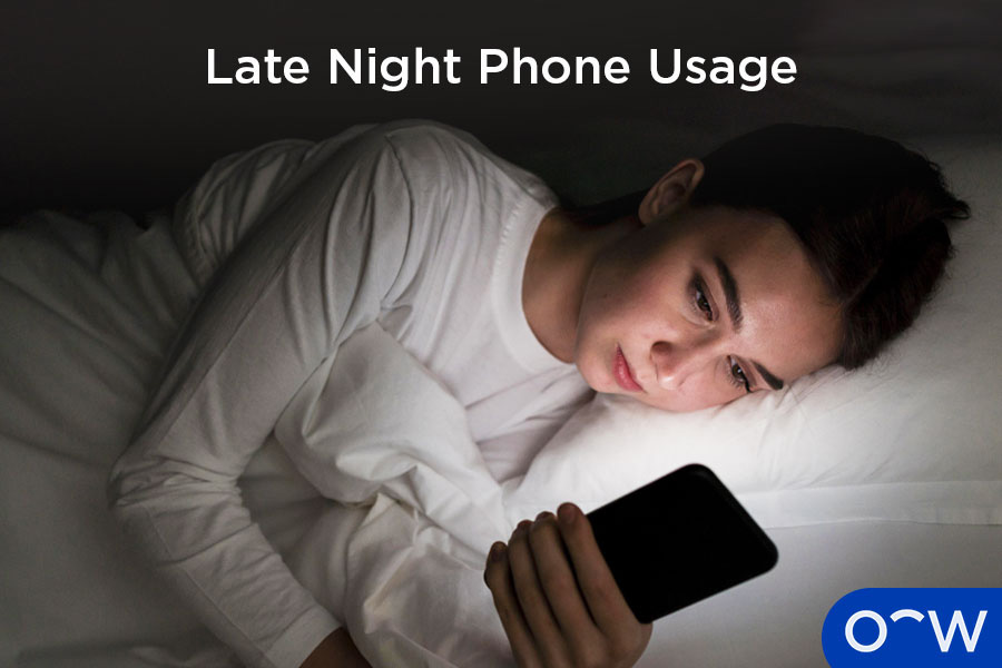 A woman lying in bed using her phone and experiencing eye pain