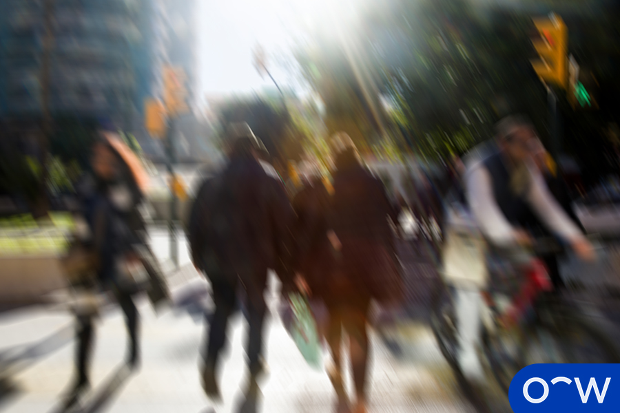 Blurry or hazy view of people walking as a possible symptom of eye problems.