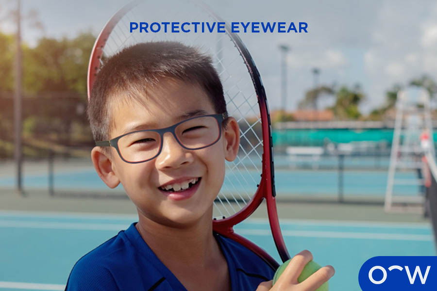 Child wearing protective eyewear and holding a tennis racket