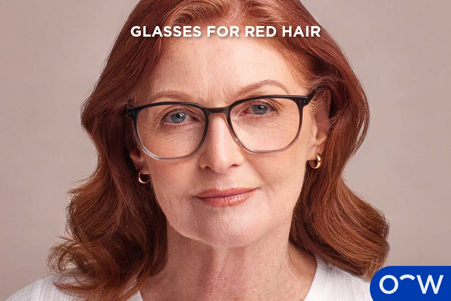 A woman with red hair wearing glasses