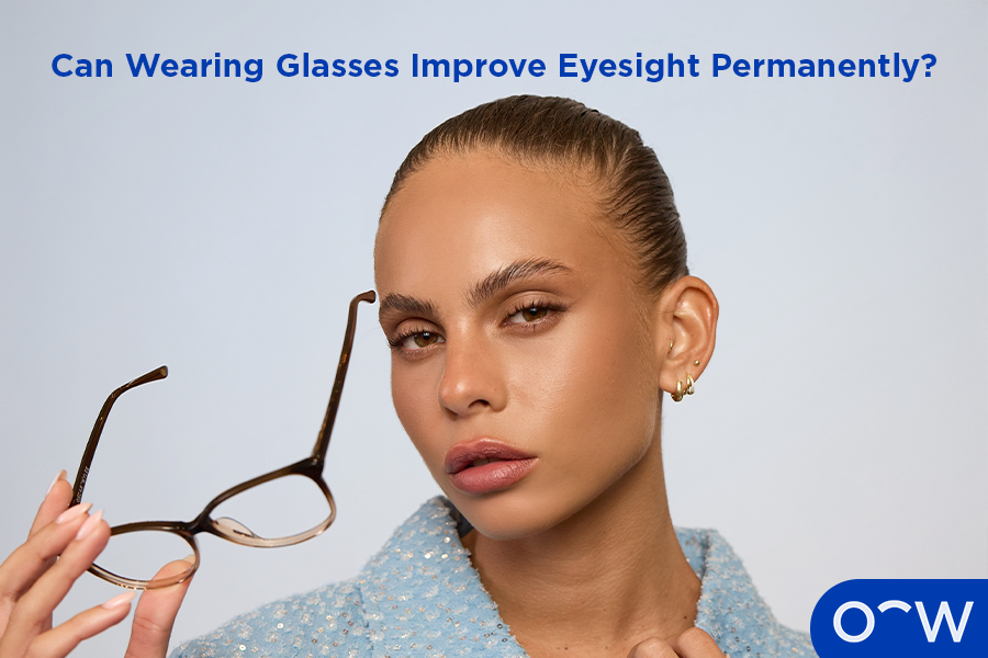 A photo of a woman holding her glasses in front of her.