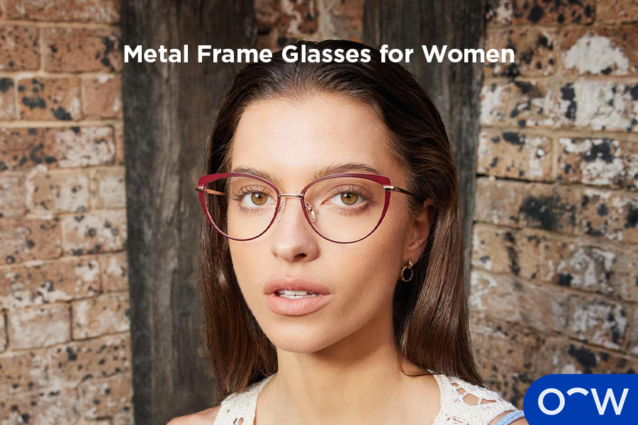 A woman posing facing the camera wearing metal cat eye glasses.
