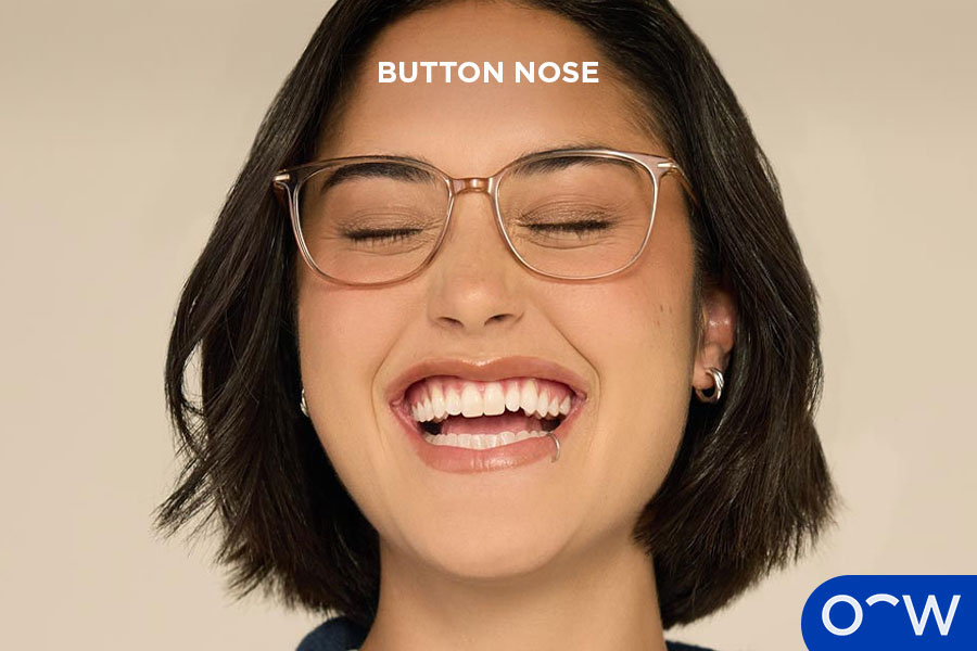 A woman with a button nose smiling.