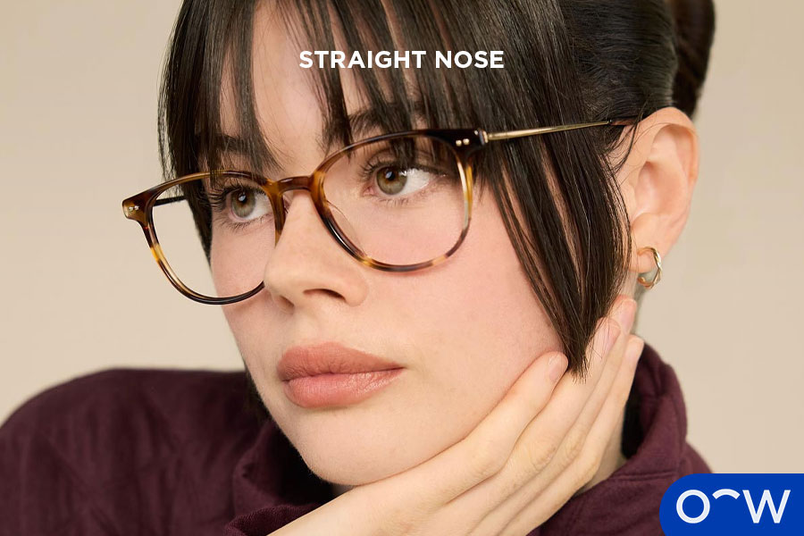 A photo of a woman with a straight nose facing side on.