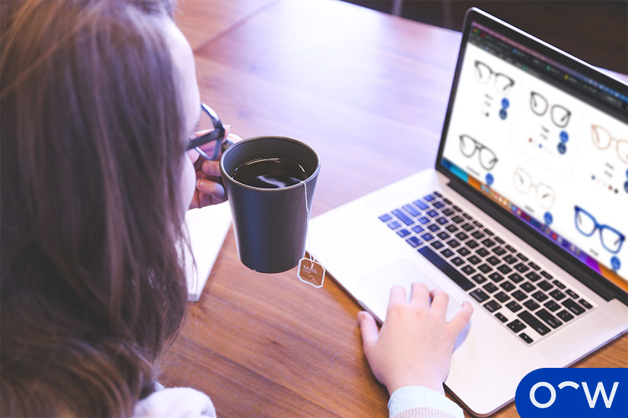 A person wearing digital glasses while using a laptop.