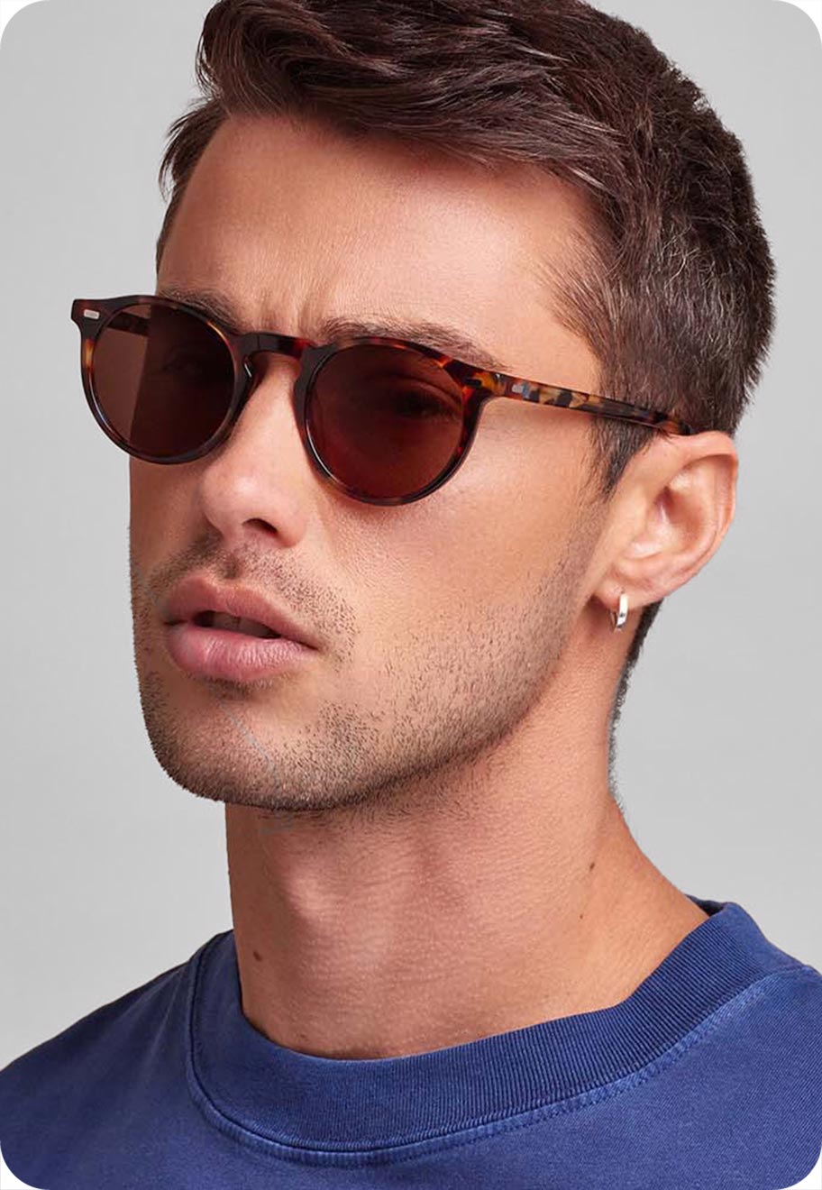 A photo of a model with a unique face shape wearing the Oscar Wylee Harris round sunglasses in Chocolate Chip.