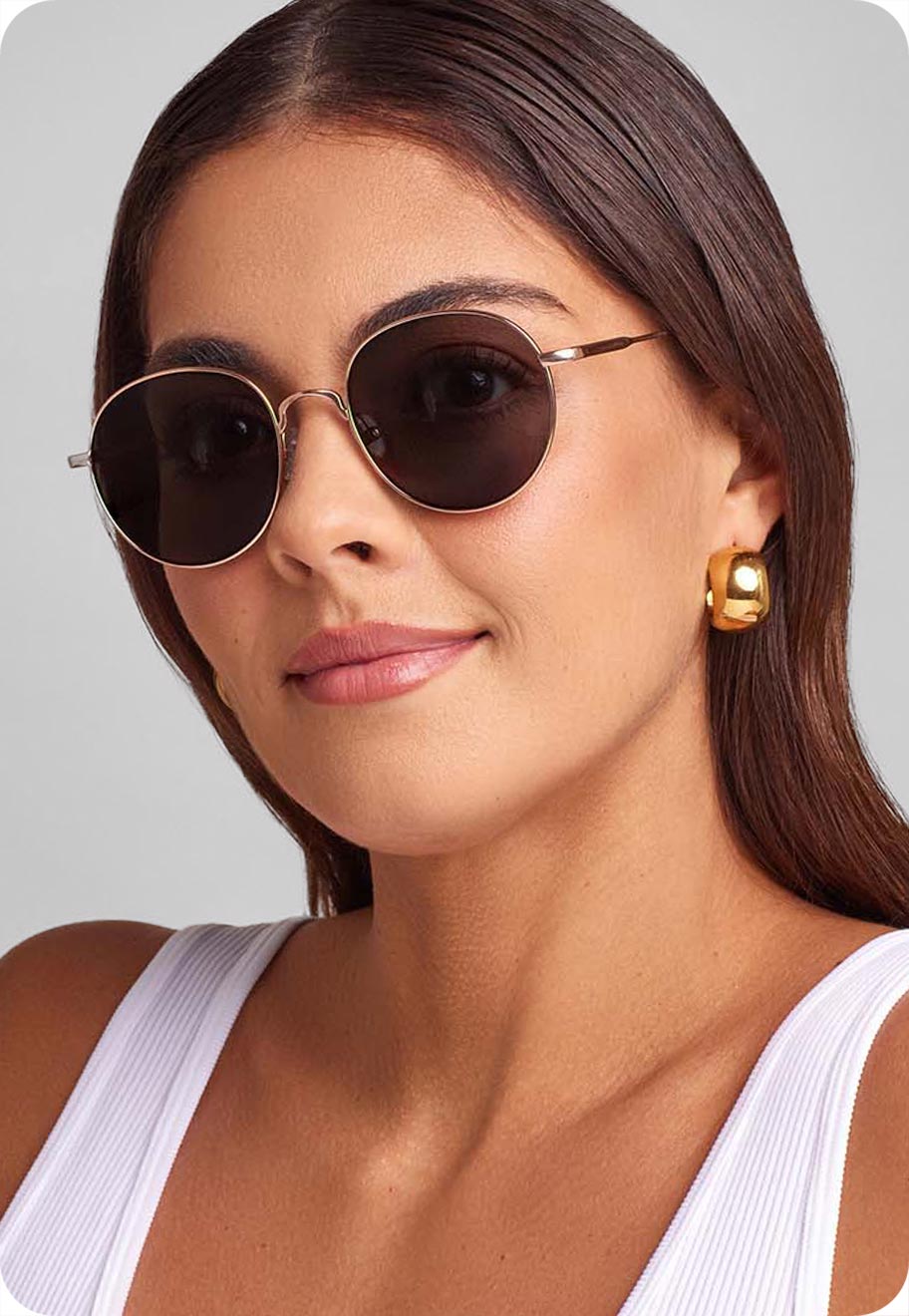 A photo of a model with a unique face shape wearing the Oscar Wylee Kato round sunglasses in Rose Gold.